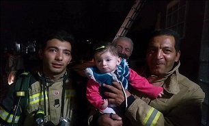 نجات دختر بچه‌ ۸ماهه از میان دود +عکس